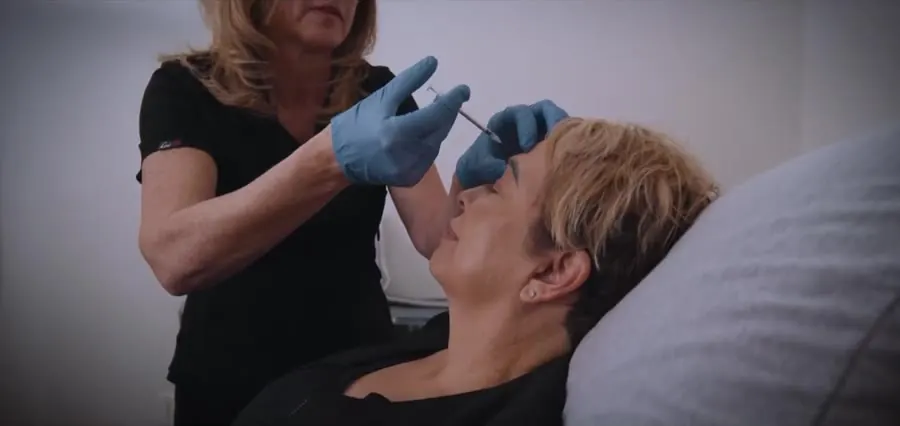 A gloved provider administering an injectable treatment to a patient