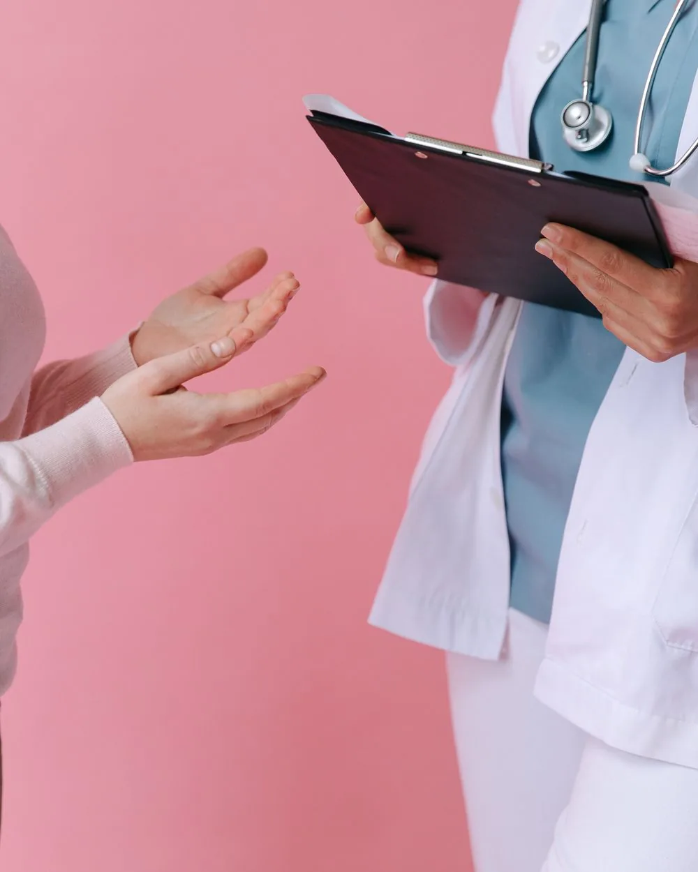 A clinician holding a clipboard during a consultation