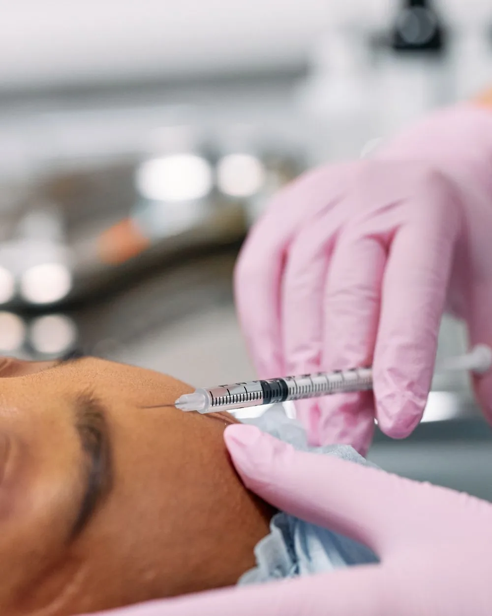 A clinician injecting a neurotoxin near the brow